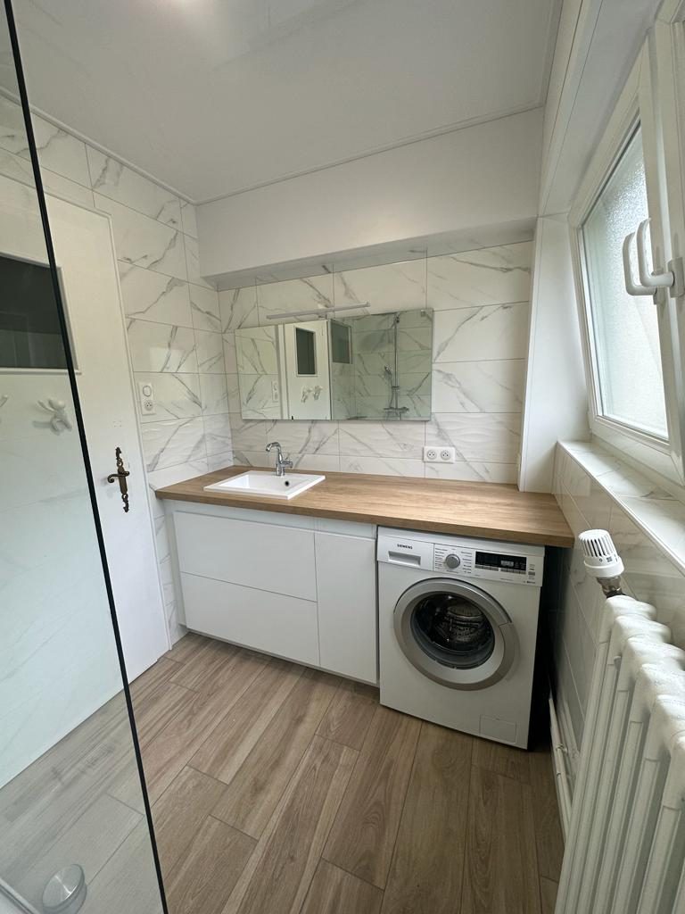 Salle d'eau avec carrelage effet marbre et sol effet bois