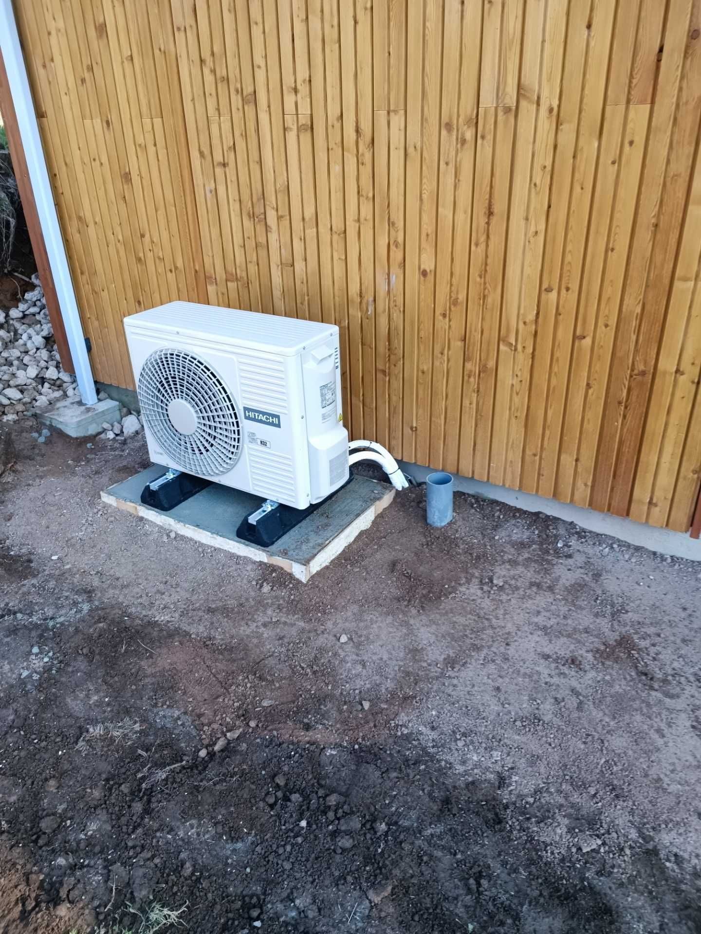 Unité extérieure posée contre un bardage bois